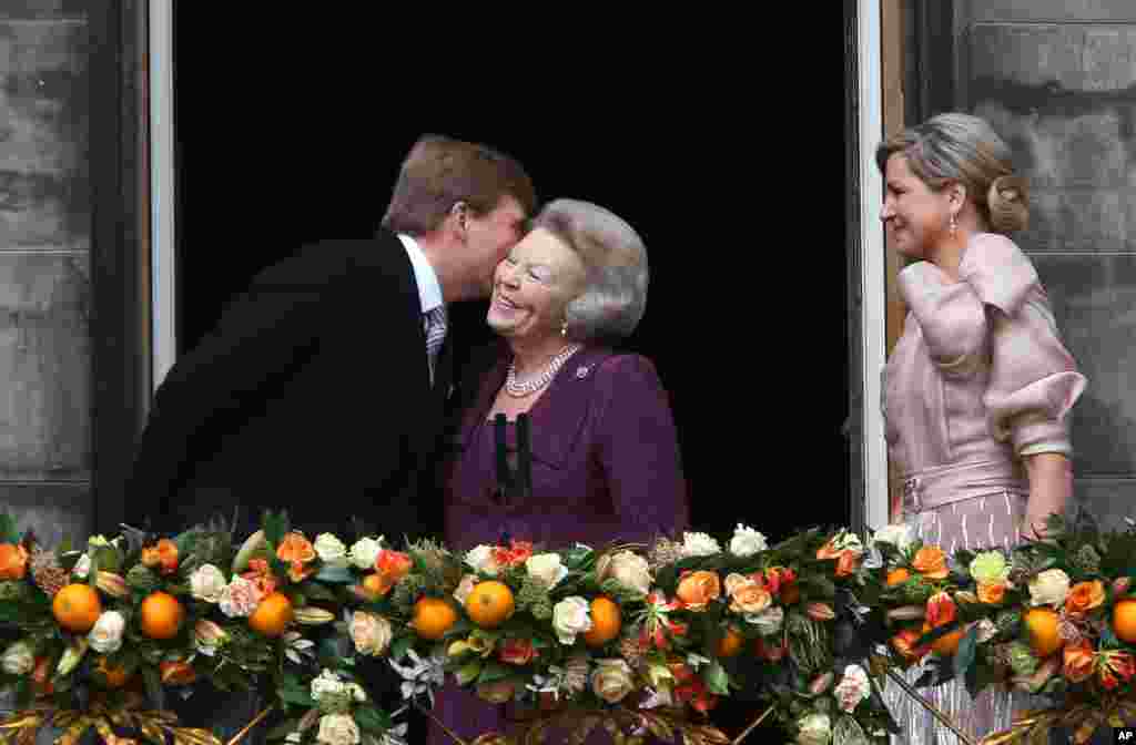 Raja Belanda Willem-Alexander mencium ibunya Putri Beatrix disaksikan istrinya Ratu Maxima di balkon Istana Kerajaan di Amsterdam.