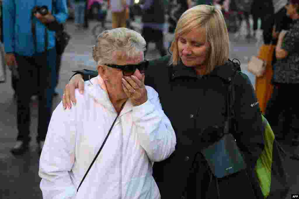People react as they gather outside Buckingham Palace in central London after it was announced that Queen Elizabeth II had died, in central London on Sept. 8, 2022.