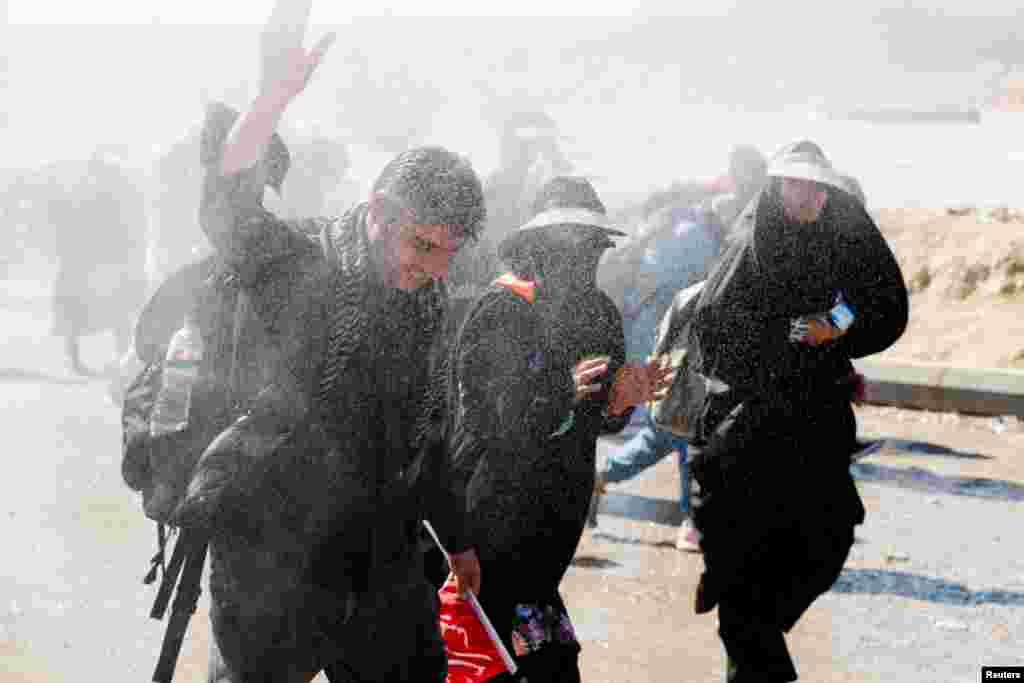 Iranian Shi'ite pilgrims walk on a road after entering Iraq through the Zurbatia border crossing between Iran and Iraq, as they head towards Iraq's holy city of Kerbala to attend the holy Shi'ite ritual of Arbaeen, in Zurbatia.