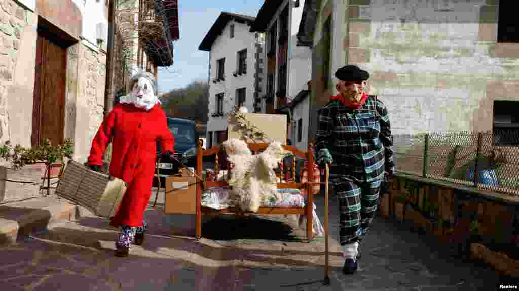 Masked villagers drag a bed during carnival celebrations in Ituren, northern Spain, Jan. 29, 2024.