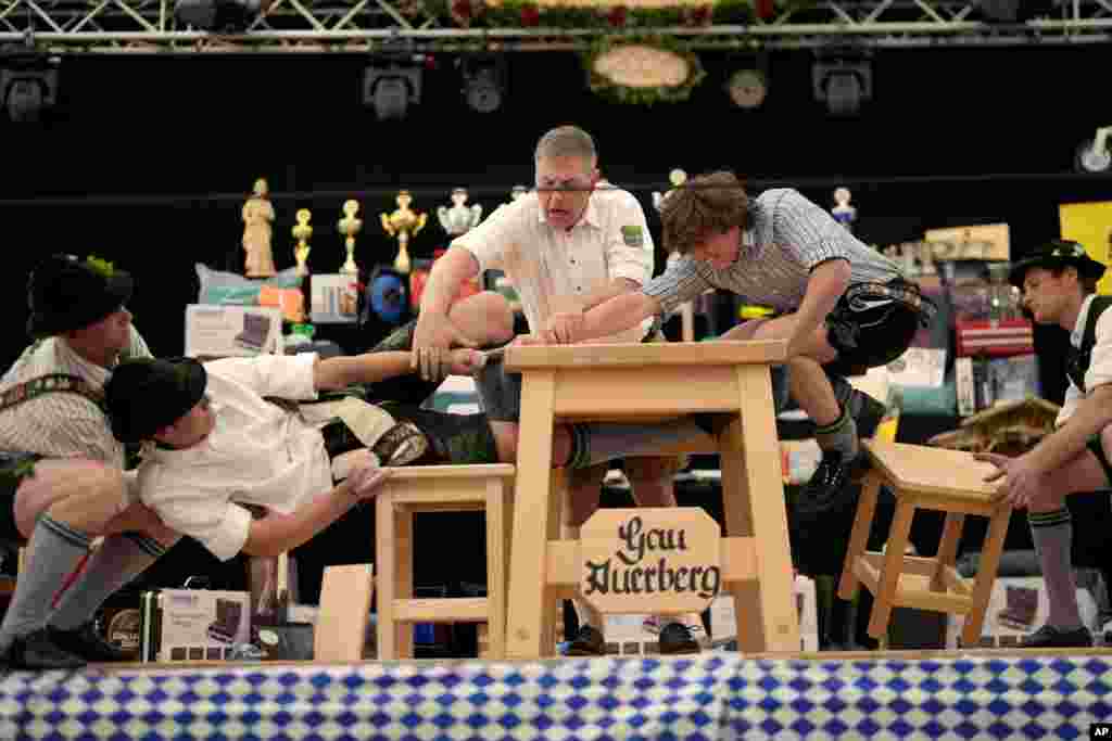 Men dressed in traditional clothes try to pull the opponent over the table at the German Championships in Fingerhakeln or finger wrestling, in Bernbeuren.