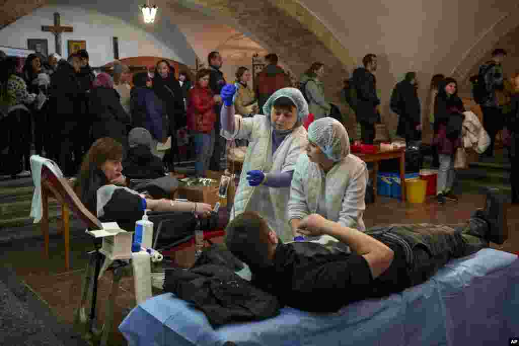 People wait in line to donate blood for wounded Ukrainian personnel in the basement of the St. Nicholas Roman Catholic Church, in Kyiv.