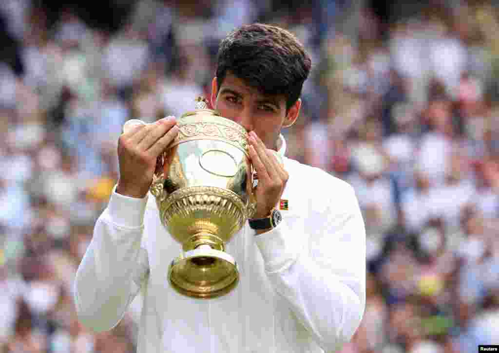 Spain's Carlos Alcaraz poses for a picture with the trophy after winning his men's singles final against Serbia's Novak Djokovic at the Wimbledon tennis championships in London.
