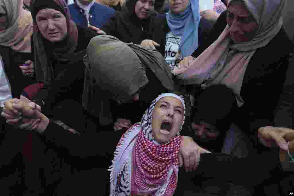 Palestinian Fayrouz Safi cries while she takes the last look at the body of her son Aysar Safi, 20, at the family house during his funeral in the West Bank refugee camp of Jalazoun, north of Ramallah. Safi was killed during clashes with Israeli forces at the northern entrance of al-Bireh city, Palestinian ministry of health said.