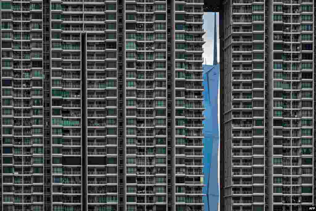 Warisan Merdeka Tower (KL118) (R), the second tallest building in the world, is pictured through a residential building in Kuala Lumpur, Malaysia.
