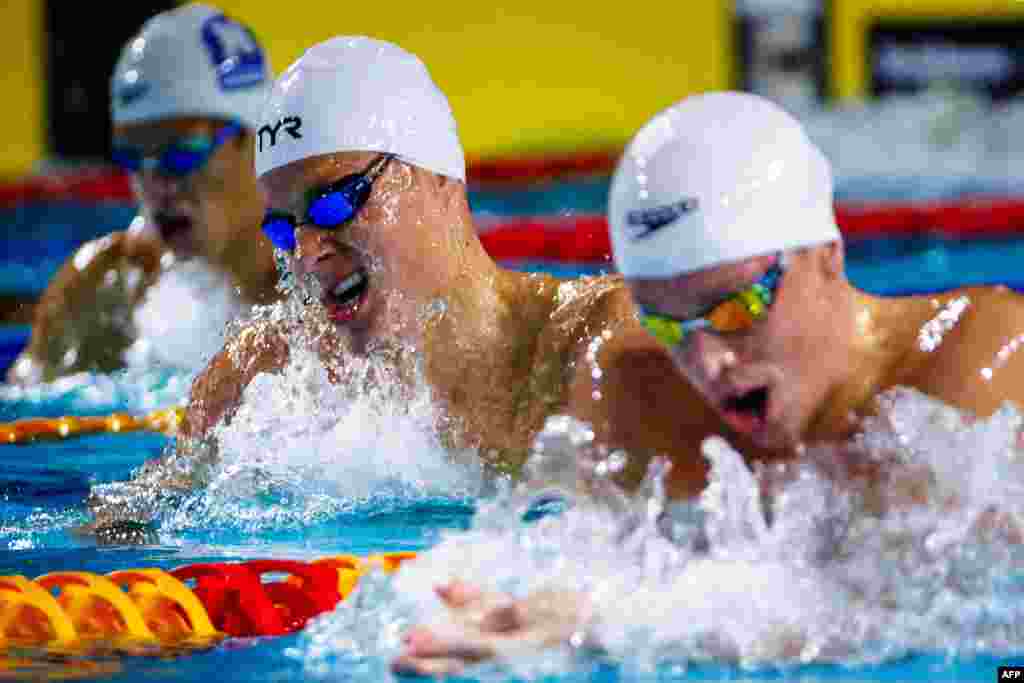 Australia's Bailey Lello, center, and Zac Stubblety-Cook, right, compete in the men's 200-meter breaststroke heats during the Australian Swimming Trials at the Brisbane Aquatic Centre.