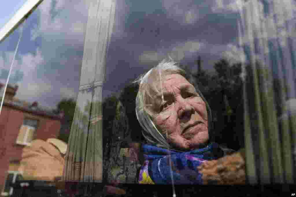Liudmila, 85, looks though the window of a bus after being evacuated from Vovchansk, Ukraine. Her husband was killed in their house after a Russian airstrike on the city. 