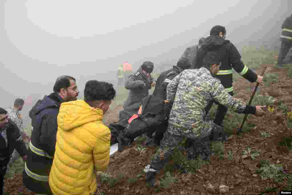 Rescue team carry a body following a crash of a helicopter carrying Iran's President Ebrahim Raisi, in Varzaqan, East Azerbaijan Province. (Stringer/WANA (West Asia News Agency))