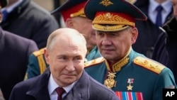 Presiden Rusia Vladimir Putin (kiri) dan mantan Menteri Pertahanan Rusia Sergei Shoigu berjalan meninggalkan area Red Square setelah menghadiri parade militer di Moskow, Rusia, pada 9 Mei 2024. (Foto: AP/Alexander Zemlianichenko, File)