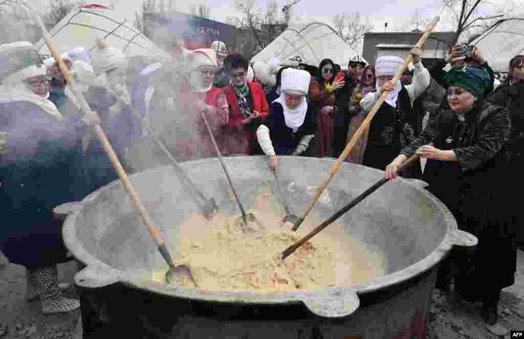 Participants cook the traditional dish 'Sumulyk' during the celebrations of Nowruz (New Year) in Bishkek, Kyrgyzstan.