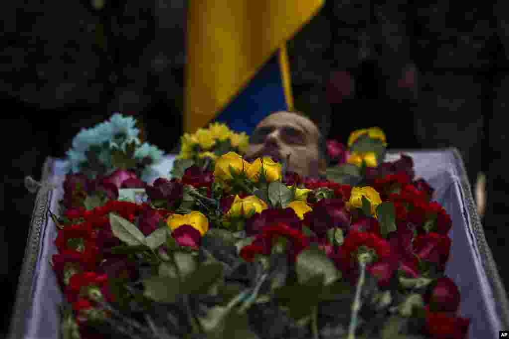 Flowers cover the body of Ukrainian serviceman Vadym Popelniuk, born in 1991, during a religious service in Independence Square in Kyiv, Ukraine.
