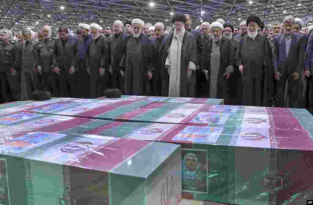 In this photo released by the office of the Iranian supreme leader, Supreme Leader Ayatollah Ali Khamenei, center right, leads a prayer over the flag-draped coffins of the late President Ebrahim Raisi and his companions who were killed in a helicopter crash, at the Tehran University campus, during a funeral ceremony for them in Tehran. 