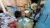 Seorang pekerja Palestina berdiri di samping kotak bantuan yang berlumuran darah, di pusat distribusi bantuan UNRWA usai serangan Israel di Rafah, Jalur Gaza selatan, 13 Maret 2024.