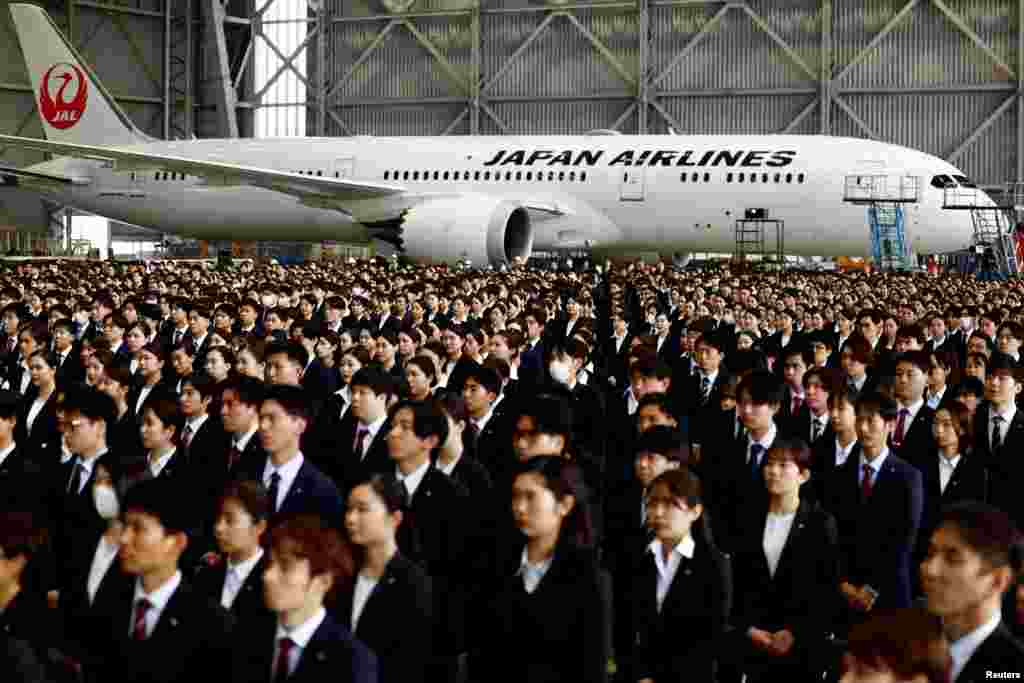 Newly hired employees of Japan Airlines (JAL) group attend an initiation ceremony at a hangar of Haneda airport in Tokyo.