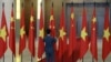 资料照：一名男子在越南国会大厦内整理中越两国国旗准备迎接中国领导人习近平的到访。（2015年11月6日）