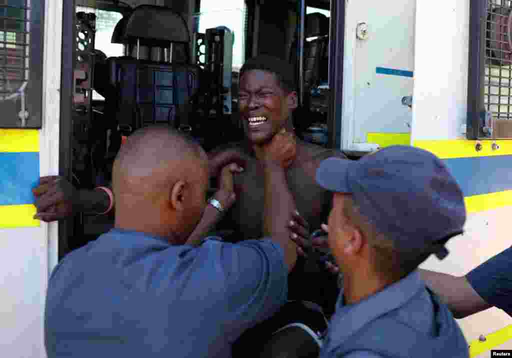 Police officials detain a protester from Sir Lowry's Pass Village during a protest over water supply in the area in Cape Town, South Africa.