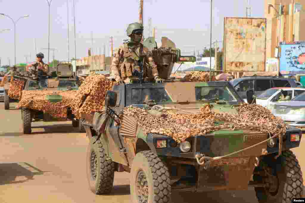 A convoy of French troops based in Niger drives by as they prepare to leave Niger, in Niamey.