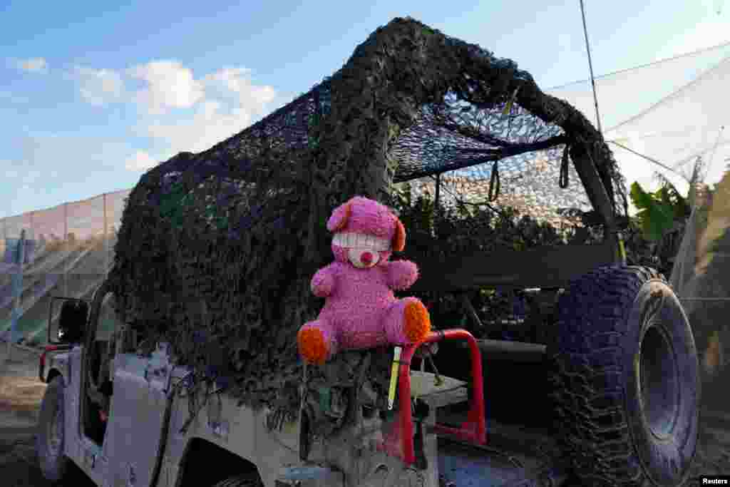 A stuffed animal with a blindfold hangs on the back of an Israeli military vehicle near the Israel-Gaza border, in Israel.