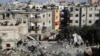 Palestinians look at the destruction after an Israeli strike on a residential building in Rafah, Gaza Strip, March 3, 2024. 
