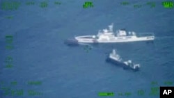 Фото від Збройних сил Філіппін, через АР. Постачальний корабель Філіппін проходить повз китайський корабель берегової охорони, Південнокитайське море, 22 жовтня 2023 року