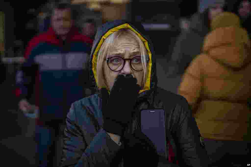 A woman reacts to sirens sound announcing new attacks, outside a supermarket in central Kyiv, Ukraine, Feb. 28, 2022.