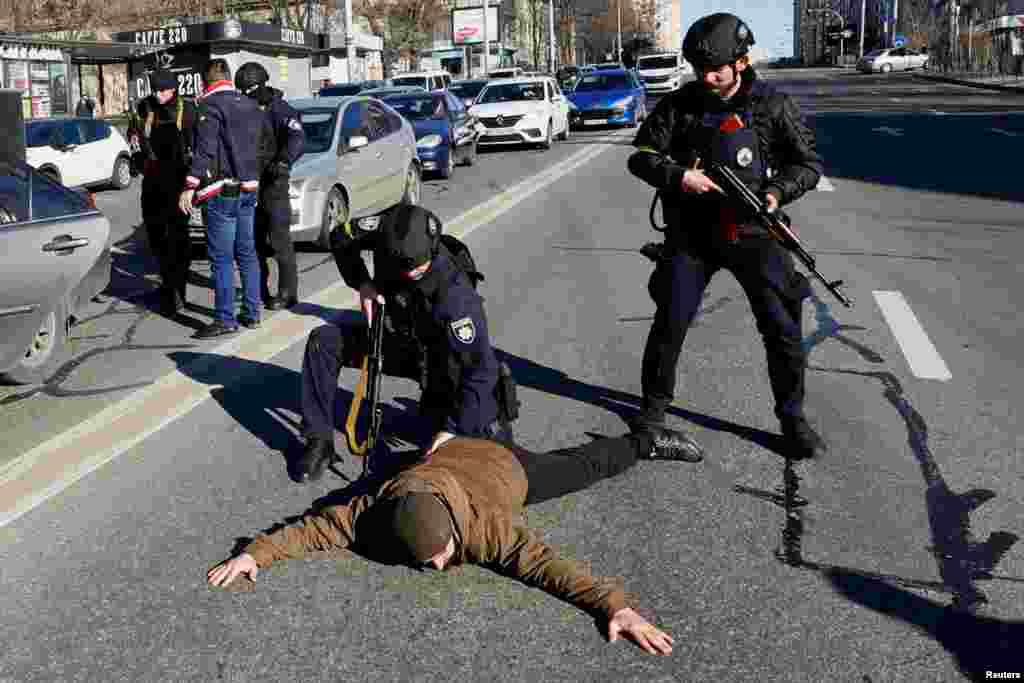 Police officers check people from a suspicious car they stopped, as Russia's invasion of Ukraine continues, in Kyiv, Ukrain, Feb. 28, 2022.