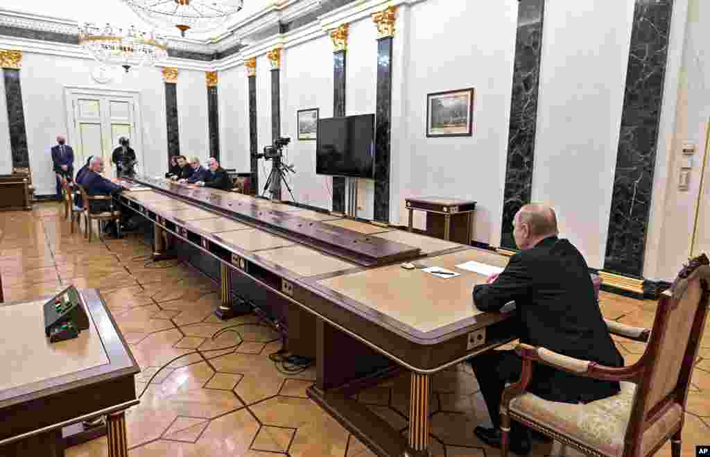Russian President Vladimir Putin, right, leads a meeting on economic issues in Moscow, Feb. 28, 2022.