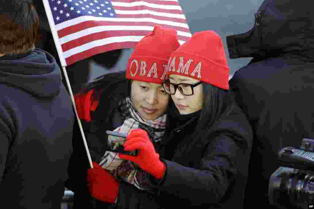 Khongorzul Battsengel, left, and Ariunbolor Davaatsogt both from Mongolia, take a picture of themselves as they wait for President Barack Obama in the 57th Presidential Inaugural Parade on Pennsylvania Ave. in Washington D.C., Jan. 21, 2013.