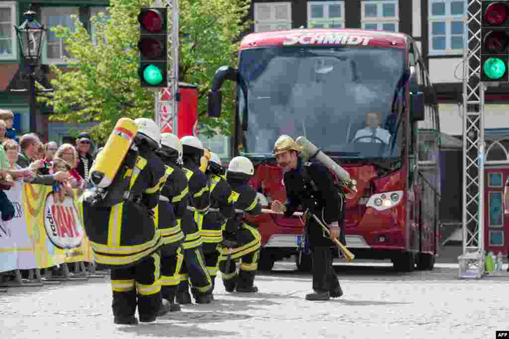 Sebuah tim yang beranggotakan para petugas pemadam kebakaran berlomba dalam edisi ke-11 kejuaraan "Menarik Bus" di kota Wolfenbuettel, Jerman.