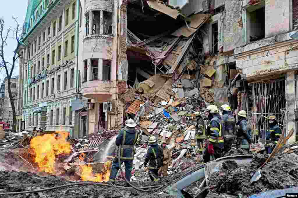 Rescuers work next to a building damaged by airstrike in central Kharkiv as Russia's attack on Ukraine continues, March 14, 2022.