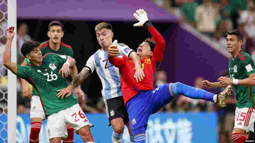 Defanse Ajanten Lisandro Martinez (25) pouse gadyen Meksik la, Guillermo Ochoa pandan premye mitan match seleksyon nasyonal Ajantin kont Meksik nan Mondyal Foutbol Qatar la, 26 Nov. 2022.