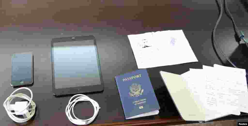 Personal possessions of U.S. citizen Matthew Todd Miller, including his passport and a ripped North Korean visa, are shown during his trial at the North Korean Supreme Court in this undated photo released by North Korea's Korean Central News Agency (KCNA), Pyongyang, Sept., 14, 2014.
