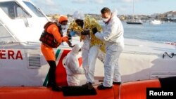 Un sobreviviente africano es ayudado a bajar de un bote en Lampedusa.