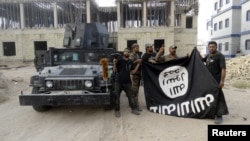 지난해 7월 이라크 안바르 주에서 정부군이 수니파 무장단체 ISIL이 점령했던 지역을 탈환한 후 ISIL 깃발을 거꾸로 들고 있다. (자료사진)