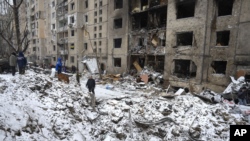 Воронка от взрыва рядом с жилым домом, разрушенным после российской атаки во вторник, в Киеве, Украина, среда, 3 января 2024 года. 