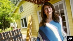 File — Homeowner Ingrid Auyon, an attorney, outside her Los Angeles-area home. On average, single women own more homes than unwed men in the nation's 50 largest metropolitan areas, according to an analysis of U.S. Census Bureau data.