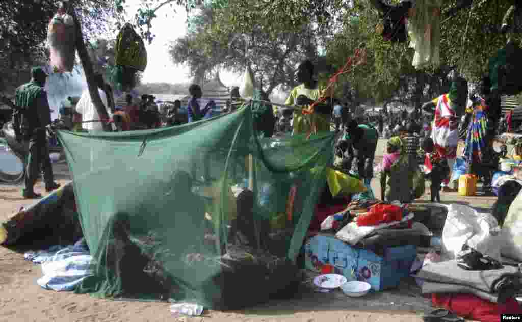 Deslocados de guerra juntam-se numa rede mosquiteira, fugidos do conflito entre o exército sul-sudanês e os rebeldes da cidade de Bor a 180km da capital Juba. Dez. 30, 2013.