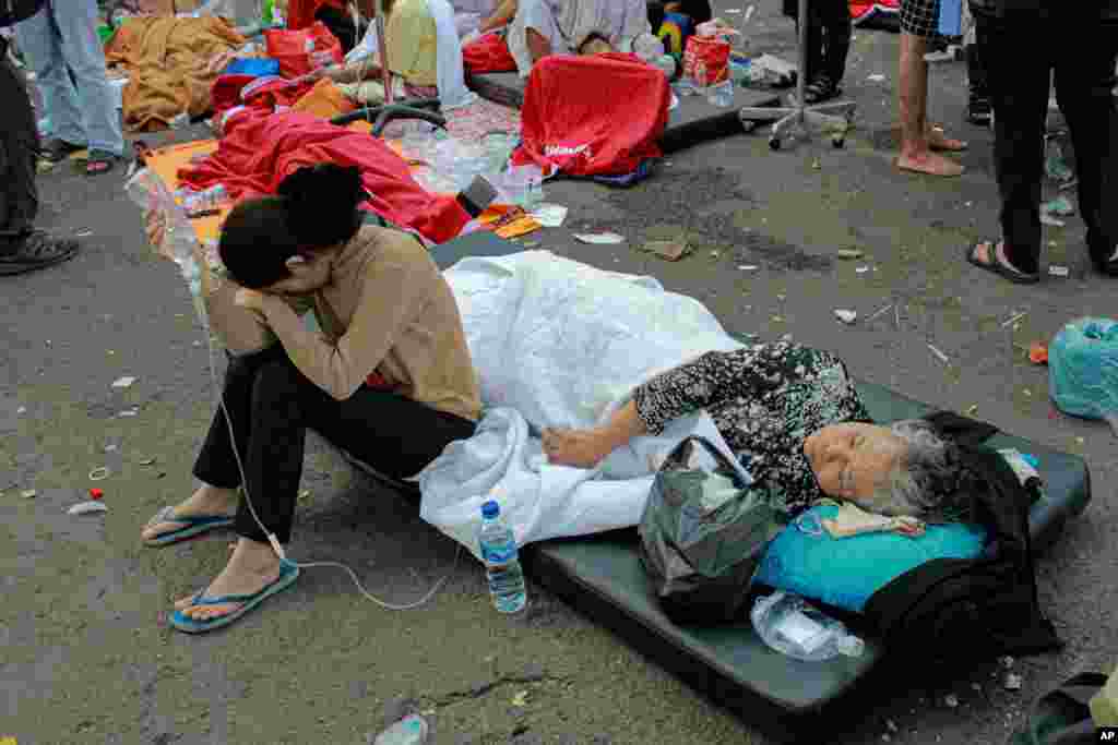 Earthquake survivors are treated outside of a hospital in Cianjur, West Java, Indonesia. A powerful earthquake has toppled buildings on the country's densely populated main island, killing at least 162 people and injuring hundreds. 