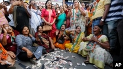 Supporters of India's main opposition Congress party tear toy currency notes and shout sloganS during a protest on the first anniversary of the Nov. 8 demonetization announcement, in Ahmadabad, India, Wednesday, Nov. 8, 2017. 