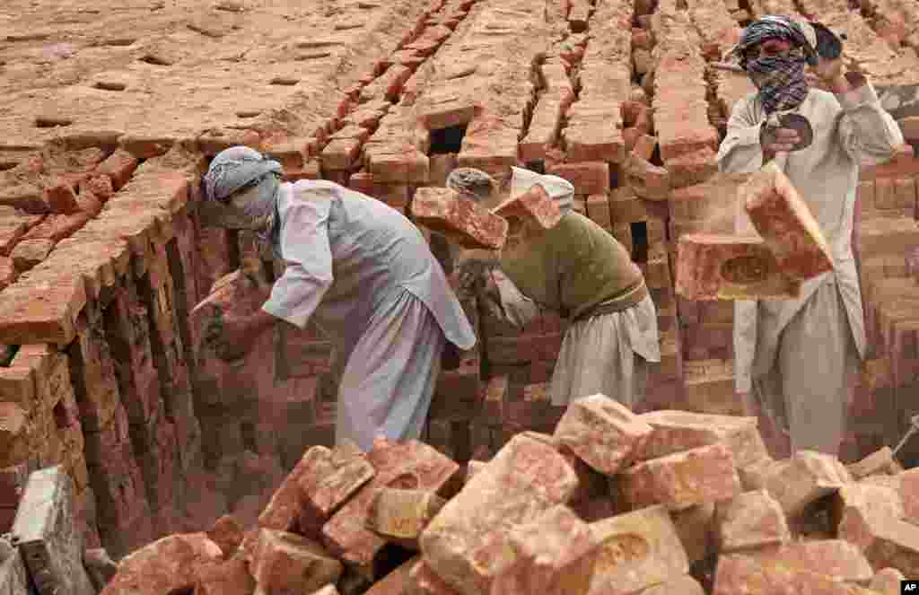 Para pekerja Afghanistan bekerja di sebuah pabrik batu bata di pinggiran Kabul.