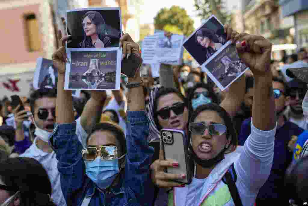Women hold up pictures of Iranian Mahsa Amini as they shout slogans during a protest against her death, outside Iran's consulate general in Istanbul, Turkey, Sept. 21, 2022.