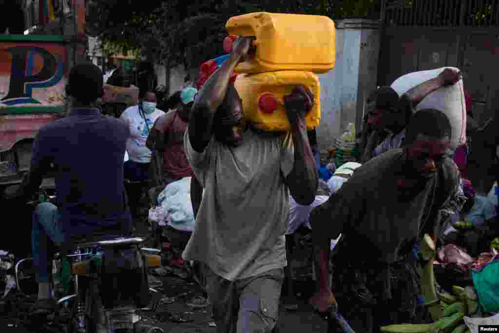 A man carries containers used for oil and gasoline during fuel shortages in Port-au-Prince, Haiti, Oct. 30, 2021.