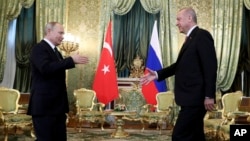 Russia's President Vladimir Putin, left, walks to shake hands with Turkey's President Recep Tayyip Erdogan, right, as he welcomes him prior to their meeting in Moscow, Russia, April 8, 2019.