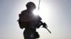 FILE - A U.S. Marine watches Afghan commandos take part in a combat training exercise at Shorab Military Camp in Lashkar Gah, Helmand province, Aug. 27, 2017.