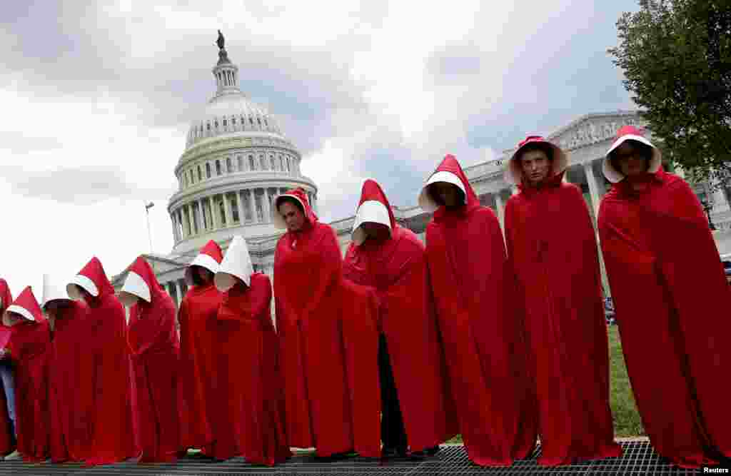 Women dressed as handmaids from the novel, film and television series "The Handmaid's Tale" demonstrate against cuts for Planned Parenthood in the Republican U.S. Senate healthcare bill at the Capitol in Washington, June 27, 2017.