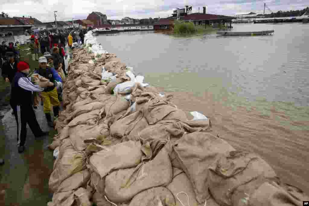 Warga membangun tanggul dari karung pasir di bantaran sungai Sava di Sremska Mitrovica, Serbia (17/5). (AP/Darko Vojinovic)