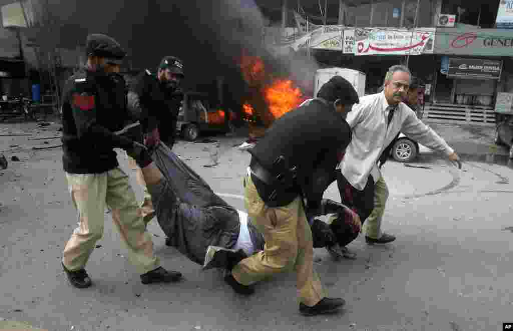 Pakistani police officers and a volunteer rush an injured person to a hospital after a bombing in Lahore, Pakistan, Feb. 17, 2015.
