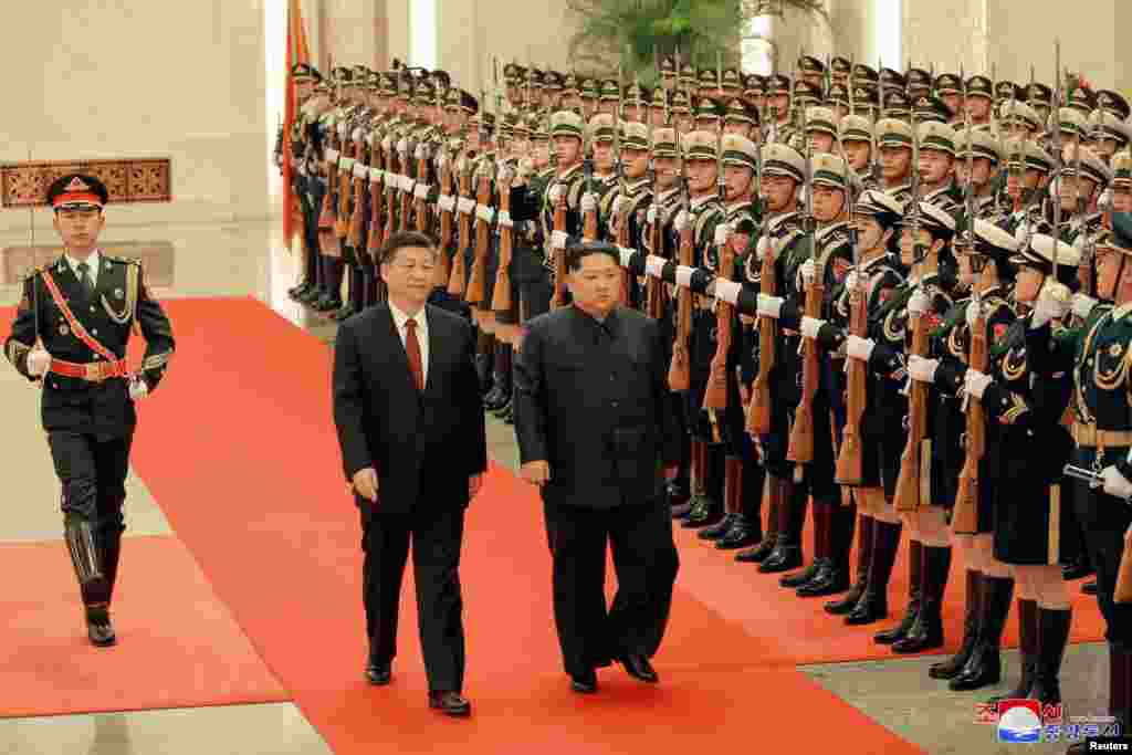 North Korean leader Kim Jong Un and Chinese President Xi Jinping inspect honor guards in Beijing, as he pays an unofficial visit to China, in this undated photo released by North Korea's Korean Central News Agency (KCNA) in Pyongyang, March 28, 2018.