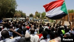 Waandamanaji nchini Sudan wakipaza sauti mbelel ya vikosi vya ulinzi wakati maandamano yakiendelea Khartoum, Sudan, Aprili. 15, 2019. 