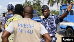 Un policier et un journaliste lors d'une manifestation à Lomé, au Togo, 14 mars 2013.